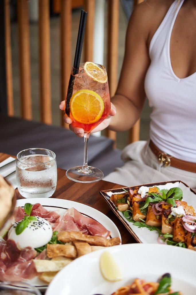 Guest holding an Aperol Spritz at Il Verde Italian restaurant on King Street in Bowen Hills Brisbane