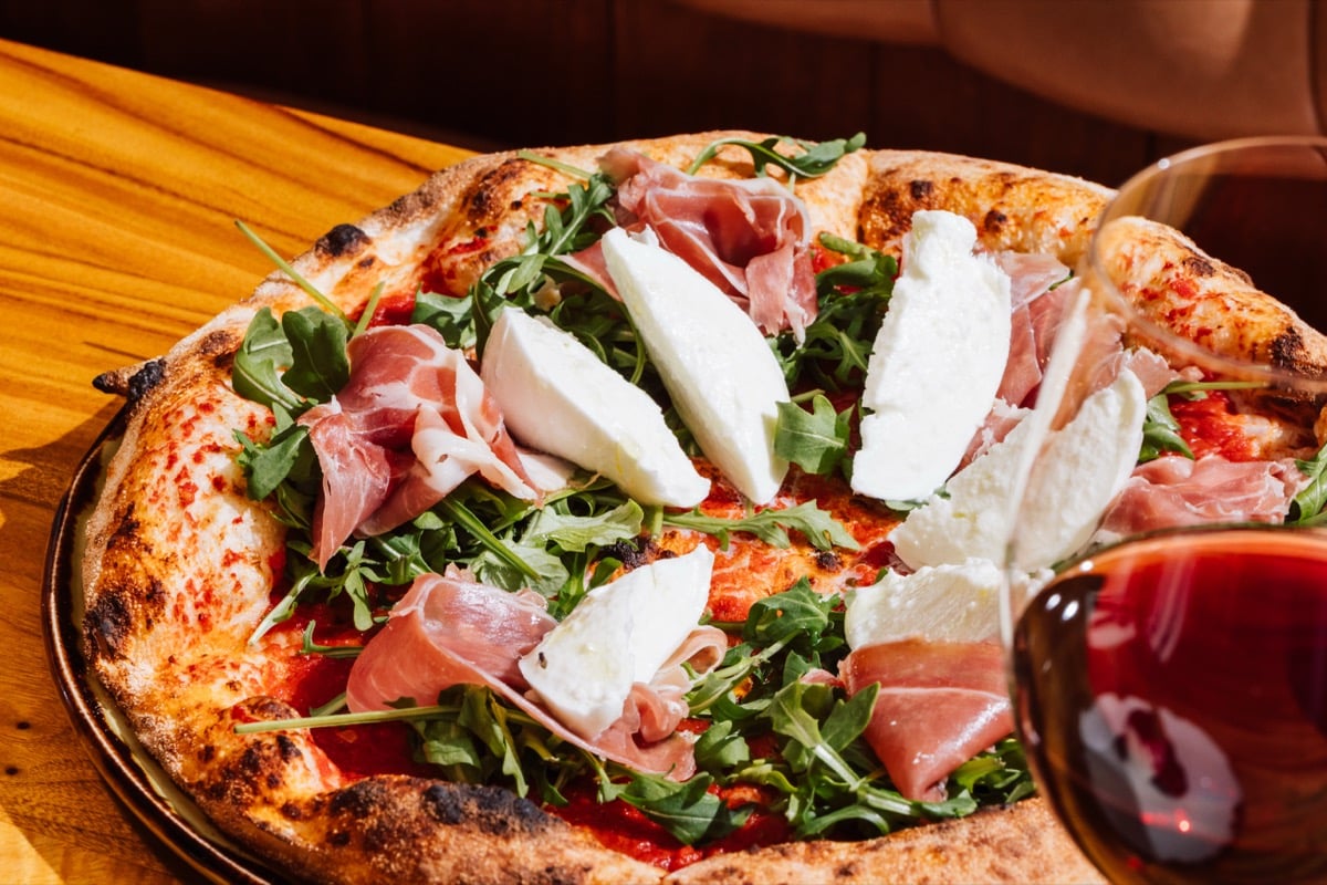 Wood-fired prosciutto pizza with fresh mozzarella and rocket at Il Verde Italian restaurant on King Street in Bowen Hills Brisbane