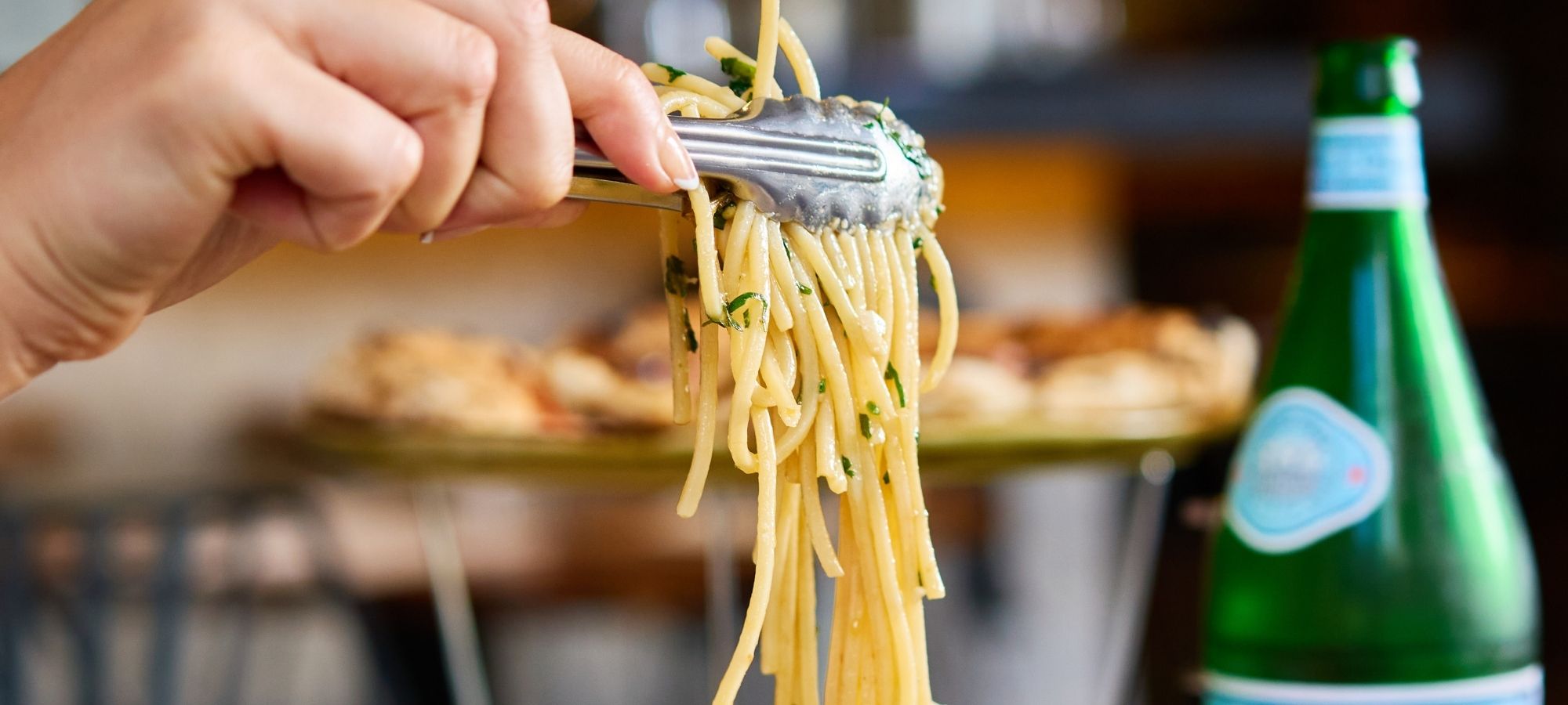 Fresh spaghetti pasta being lifted with tongs at Il Verde Italian restaurant in Bowen Hills Brisbane