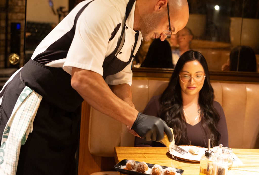 Chef serving pasta from a Grana Padano cheese wheel at Il Verde in Bowen Hills Brisbane