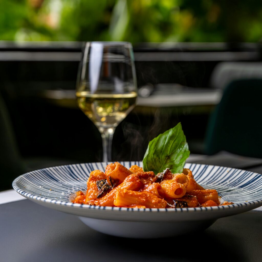 Delicious rigatoni pasta with tomato sauce and white wine in an elegant setting
